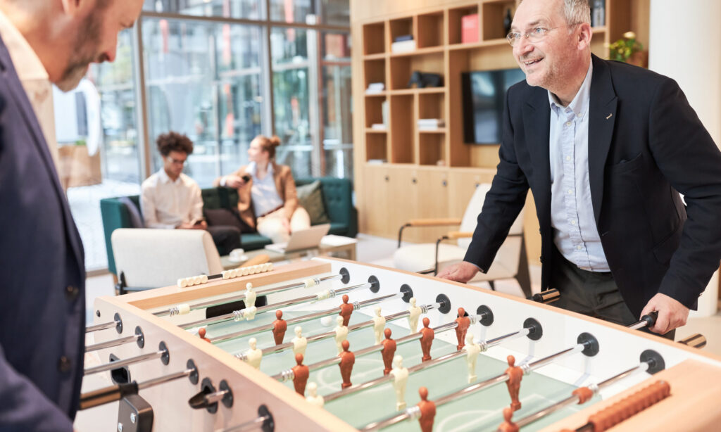 Two business men at the football table playing table football