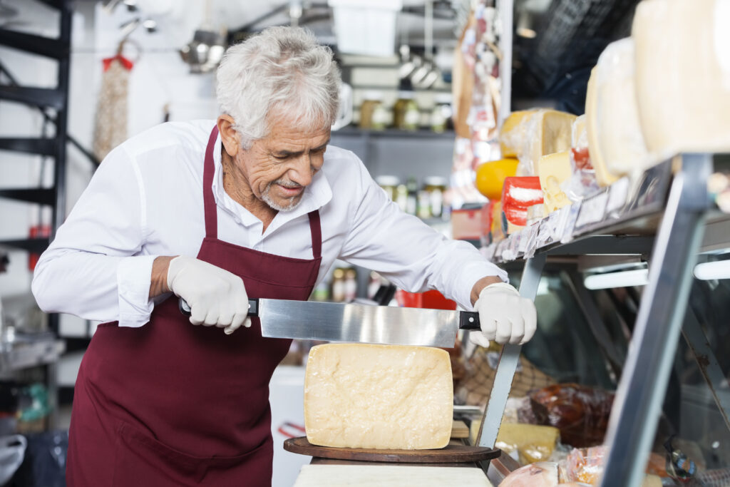 Man slicing delicious Parmesan Cheese