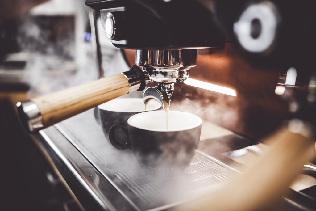 Espresso pouring from coffee machine at a cafe in Italy