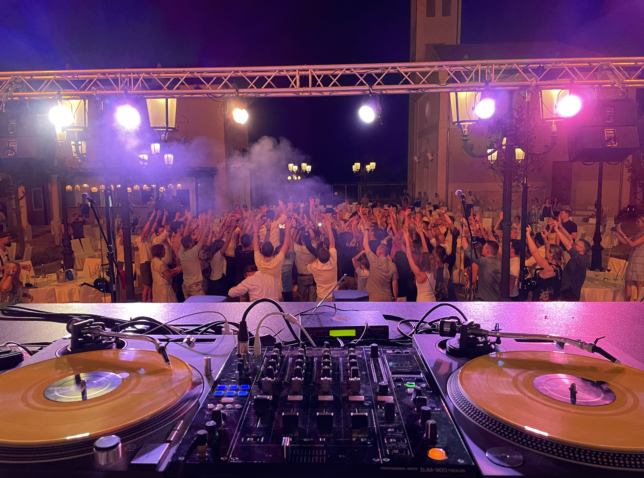 Gruppe von Leuten an Beach Party, DJ Pult und Beleuchtung.