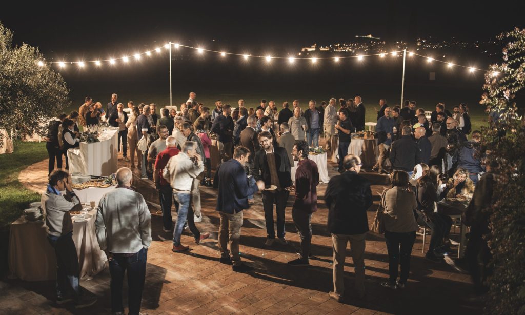 Gruppe von Menschen bei einem Treffen, Aperitif im Freien bei Nacht, Lichter.