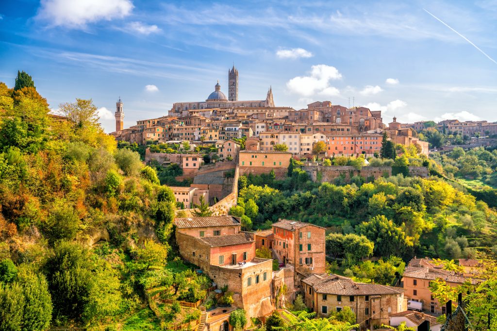 Aussicht auf Siena, Bäume und blauer Himmel.