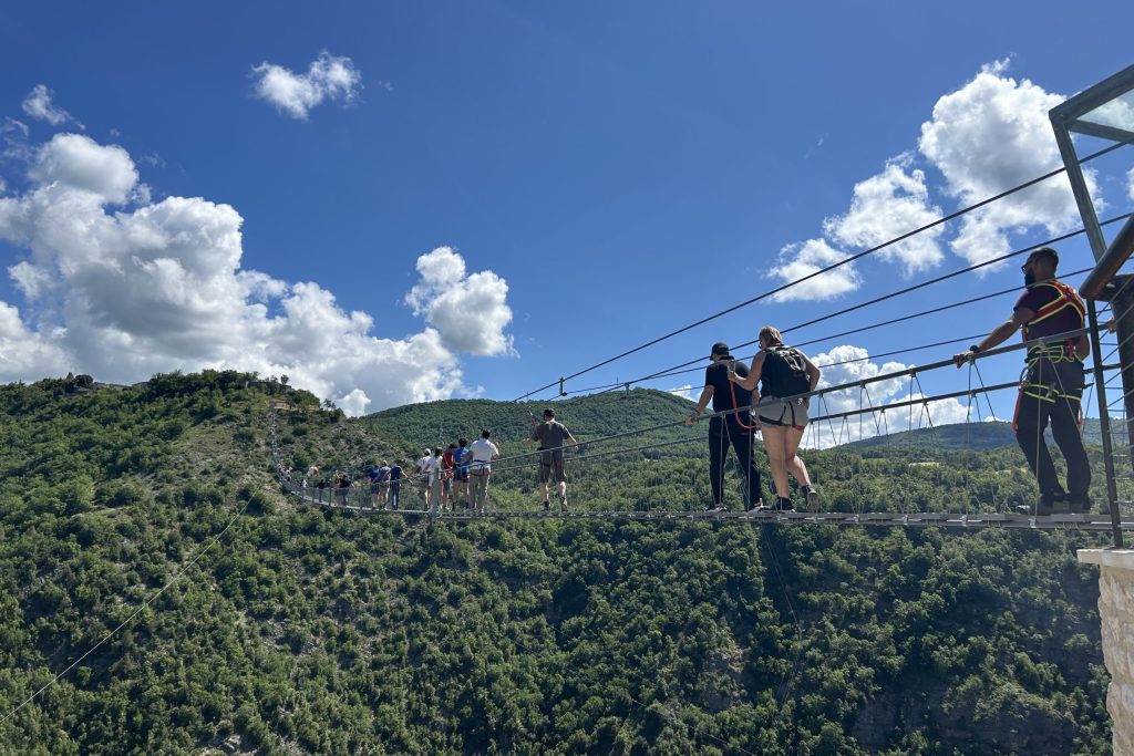 Gruppe von Leuten auf Hängebrücke.