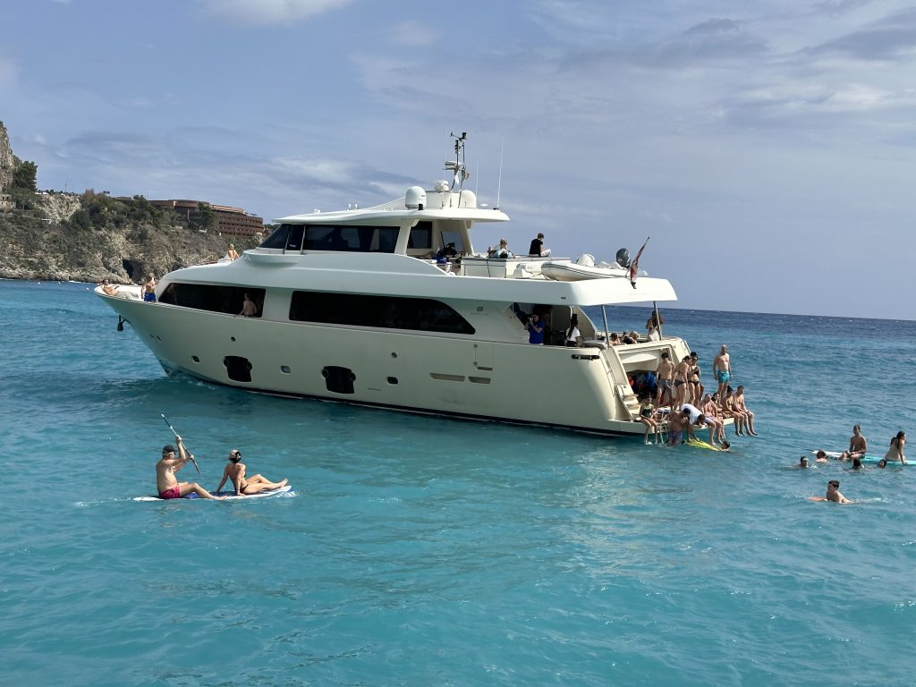 Yacht in Italy with people swimming in the sea.