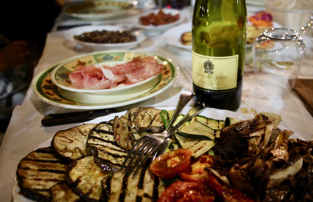 Tisch mit toskanischen Spezialitäten, Gemüse und Wein.
