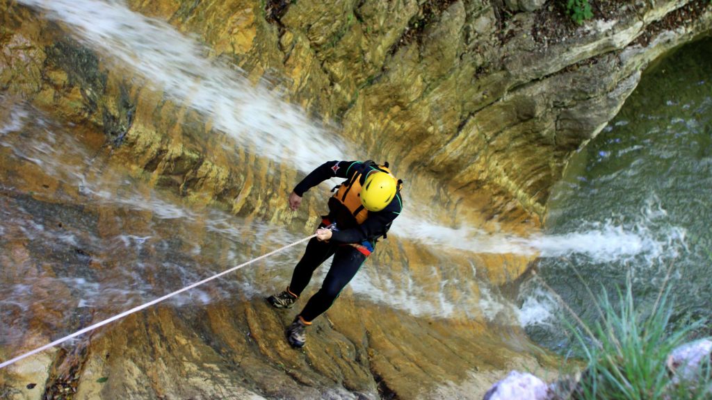 Eine Person beim Canyoning am Gardasee, Team Building Aktivität.