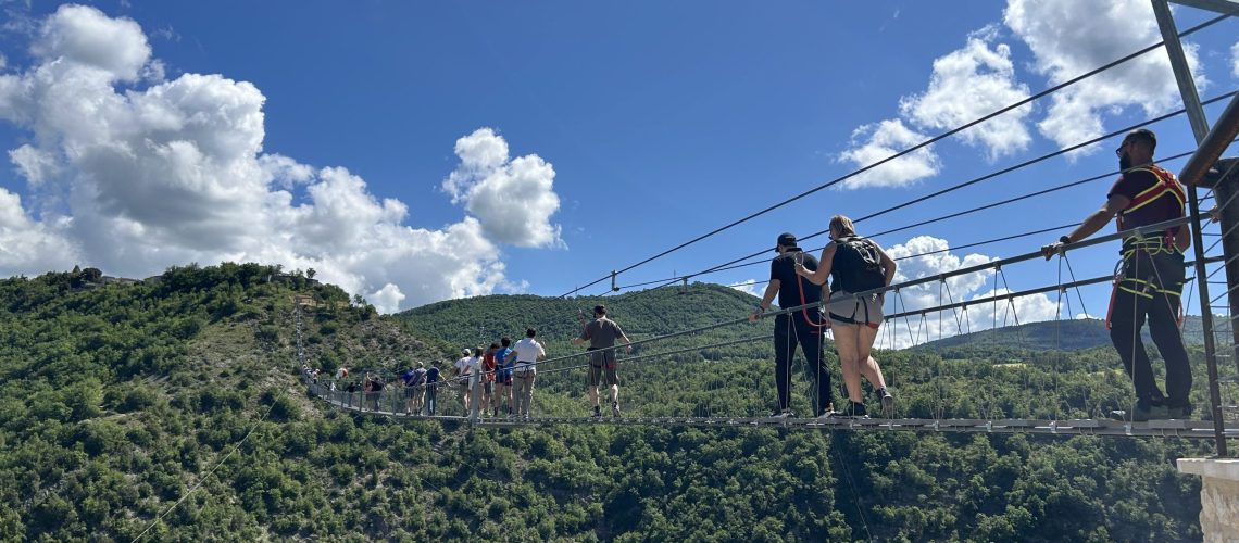 Gruppe von Leuten auf Hängebrücke.