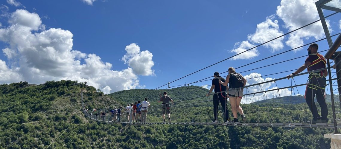 Gruppe von Leuten auf Hängebrücke.